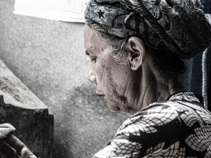 Alte Frau beim Nähen in Bali